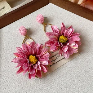 Detailed view of pink raffia flower earrings with delicate yellow stamen
