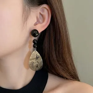 Elegante Vintage-Ohrringe im chinesischen Stil mit schwarzen Perlen an einem Frauenmodell