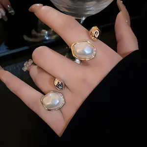 Detailed close-up of vintage gold and silver plated open rings with oval pearls