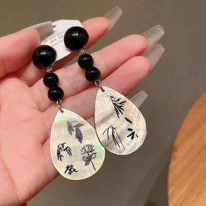 Detailansicht von Muschelohrringen im neuen chinesischen Stil mit Bambusgravur.