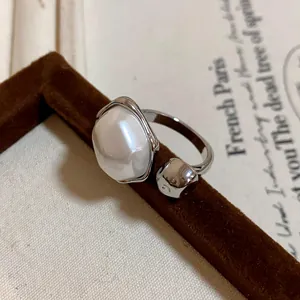 Close-up of a vintage luxury gold-plated open ring featuring a large irregular pearl