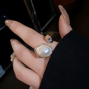 Close-up of a vintage style silver-toned open ring with a polished oval pearl detail