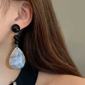 Nahaufnahme von Neo-Chinesischen Vintage-Ohrringen mit blauem Bambus-Muschel-Anhänger.