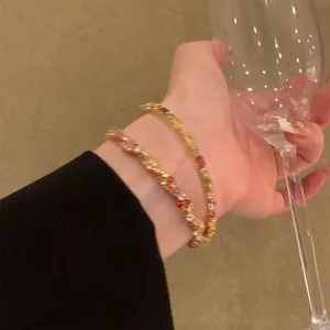 Vista dettagliata in primo piano di eleganti braccialetti in zircone colorato al polso