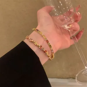 Primo piano dettagliato di braccialetti con strass colorati indossati al polso da un modello