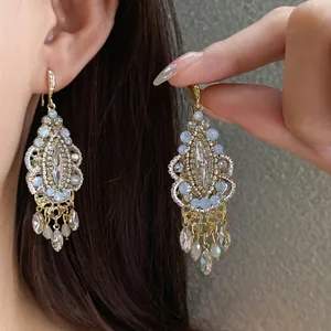 Ethnic style rhinestone earrings featuring water drop tassels and retro gold finish