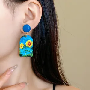 Detailansicht von lebhaften Acryl-Sonnenblumen-Ohrhängern an einem asiatischen Model