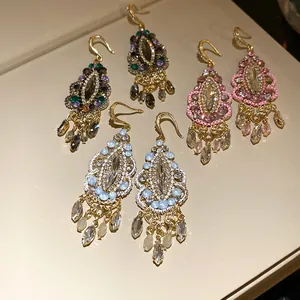 Detailed shot of ethnic vintage rhinestone teardrop tassel earrings in three vibrant colors.