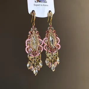 Macro detail view of ethnic rhinestone tassel earrings with pink beads and crystals