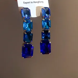 Gros plan de boucles d'oreilles vintage avec strass bleus carrés et dégradé de quatre niveaux