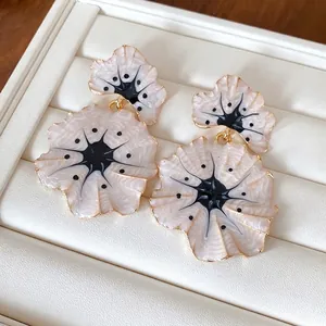 Elegant ginkgo flower drop earrings with a pearly drip oil finish on a white box