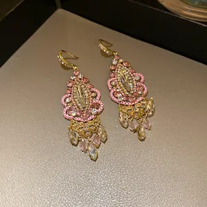 Macro detail of vintage ethnic dangle earrings with pink crystals and teardrop tassels