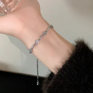 Elegant silver adjustable bracelet with sparkling zircon flower clusters on a female wrist