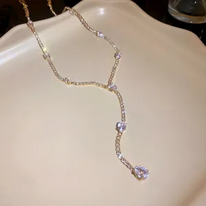 Sparkling gold-toned tassel necklace with pear-cut zircon pendants on an elegant tray