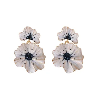 Elegant cream ginkgo leaf drop earrings with gold trim and artistic black enamel details