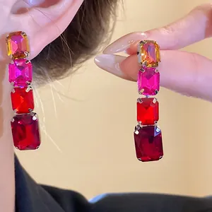 Gros plan de boucles d'oreilles pendantes en cristal rectangulaire avec un dégradé de couleurs