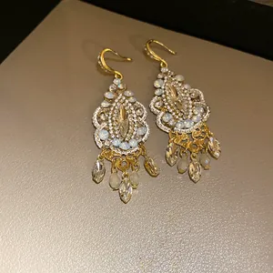 Detailed view of vintage ethnic earrings with clear rhinestones and golden tassels