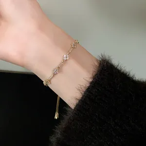 Detailed view of an adjustable gold flower bracelet with sparkling zircons on wrist.