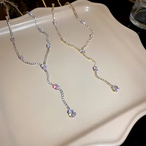 Macro view of teardrop zircon tassel necklaces in gold and silver tones with brilliant sparkle