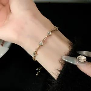 Macro view of an adjustable gold-tone bracelet with sparkling zircon flower charms