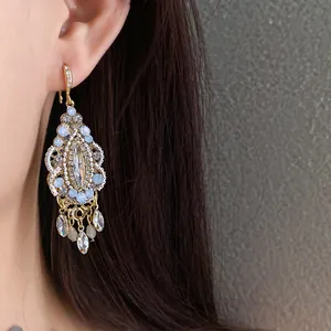 Close-up of vintage ethnic style earring with rhinestones and drop tassels on ear