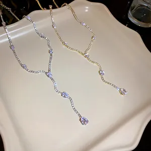 Detailed view of shimmering water drop zirconia tassel necklaces in gold and silver.