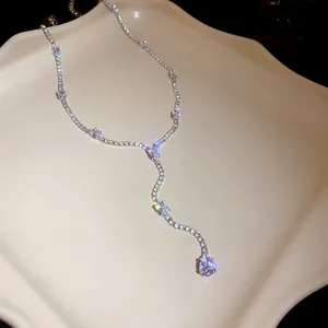 Detailed macro shot of sparkling water drop zircon tassels on a silver Y-necklace