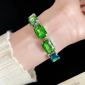 Gros plan d'un luxueux bracelet vintage avec cristaux verts sur le poignet d'une femme