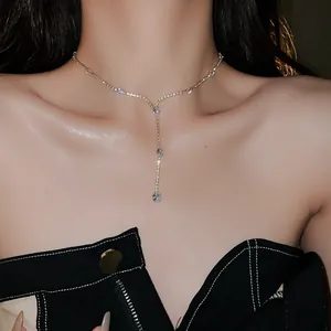Close-up detail of a delicate zircon waterdrop tassel necklace worn by an elegant model