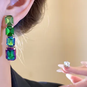 Vue détaillée de boucles d'oreilles pendantes en strass carrés de couleur émeraude