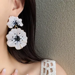 Elegant enamel ginkgo leaf drop earrings with artistic white and black floral patterns