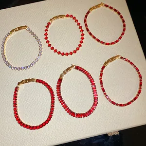 Detail view of elegant zircon bracelets with ruby red and lavender gemstones gold finish