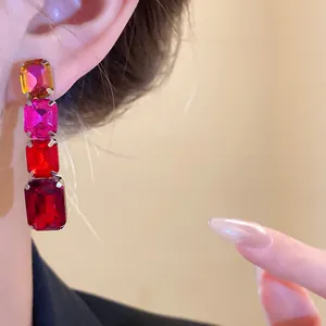 Vue détaillée de boucles d'oreilles rétro en cristal rouge et rose sur l'oreille