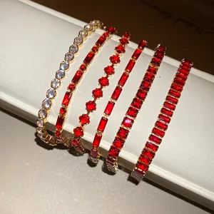 Detailed view of six vintage-style gold-plated bracelets featuring red and clear zircons.