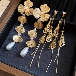 Detailed view of 18K gold plated flower pearl earrings with intricate hollow designs