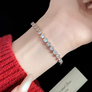 Close-up view of a sparkling zircon tennis bracelet worn on a wrist with a red sweater