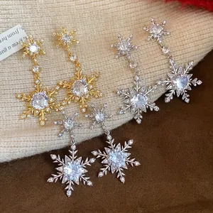 Elegant zircon snowflake dangle earrings with gold and silver finishes for winter.