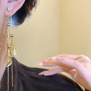 Detail view of vintage 18K gold plated long tassel earrings with heart zircon stud