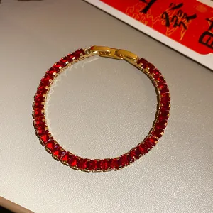 Close-up detail showing a vintage red zircon square clasp bracelet in gold finish.