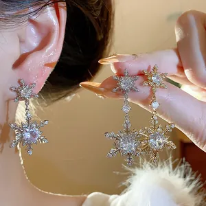 Detailed view of sparkling zircon snowflake earrings with elegant gold plating