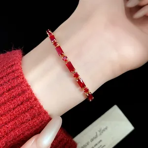 Detailed shot of a vintage gold-plated bracelet featuring red rectangular zircon stones on a wrist