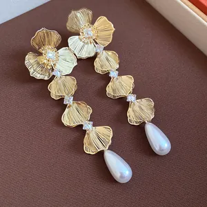 Detailed macro shot of 18K gold-plated floral earrings with zircons and pearl drops.