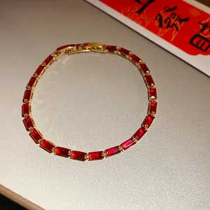 Detailed view of a vintage gold-plated bracelet with elegant red zircon stones