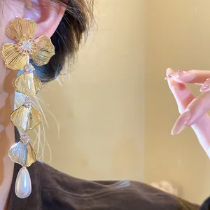 Detailed close-up of 18K gold plated tiered flower earring with zircon and drop pearl
