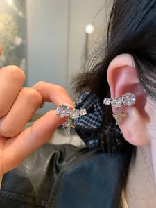 Detailed view of silver zircon cross ear cuff worn on model's ear for no-piercing style.