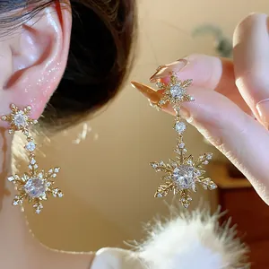 Detail shot of elegant gold-plated snowflake earrings adorned with sparkling cubic zirconia