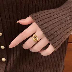 Close-up of a double-layered vintage gold ring featuring a brown tiger eye stone.