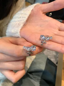 Macro view of luxurious zircon-studded cross ear clips held in hand for scale.