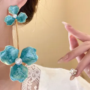 Detailansicht türkisfarbener Emaille-Blumenohrringe mit Perlen und Goldverzierung