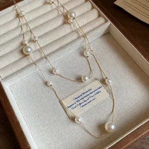 Detailed close-up of double-layer French vintage necklace with pearls and gold chain.